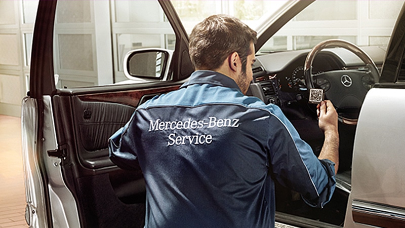 Mercedes-Benz service employee affixing a rescue sticker to a vehicle